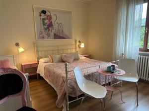 a bedroom with a bed with a table and chairs at The little lake Verona villa in Bovo
