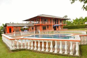 a house with a pool in front of a building at Finca Hotel Montebello in Quimbaya