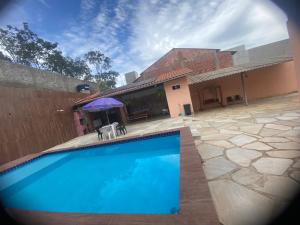 a swimming pool in front of a house at Suítes Goiabal in Pirenópolis