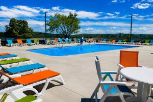 a pool with chairs and tables and chairs at Lake it Easy at Kimberling Crossing in Kimberling City