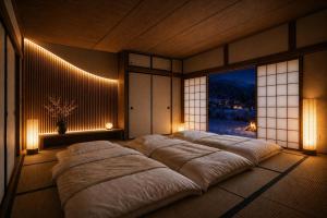 a bedroom with a large bed and a large window at 雪灯庵 in Iiyama