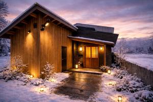 a log cabin with lights in the snow at 雪灯庵 in Iiyama