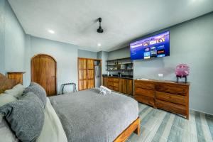 a bedroom with a large bed and a tv at Casa Del Toro in Barra de Navidad +93 photos