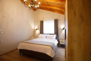 a bedroom with a bed with a chandelier and a window at Panorama Hills Entire Villa in Gjirokastër +130 photos
