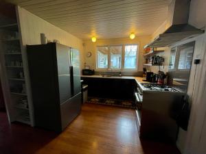 a kitchen with a stainless steel refrigerator and a sink at Ongarue Cottage in Ongarue +30 photos