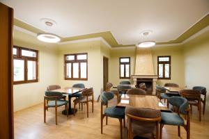 a room with tables and chairs and a fireplace at Panorama Hills Entire Villa in Gjirokastër