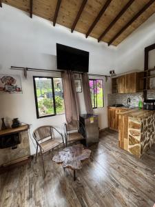 a living room with a table and a kitchen at Refugio del Lago in Envigado