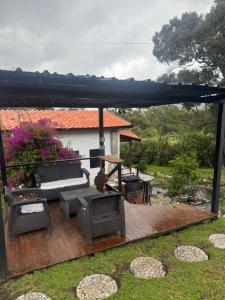 a patio with an umbrella and a couch and a grill at Refugio del Lago in Envigado