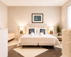 a bedroom with a large bed and two lamps at green & blue villa in Glykadi