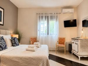 a bedroom with two beds and a tv and a window at green & blue villa in Glykadi