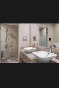 a bathroom with two sinks and a shower at St Helens in Bolton