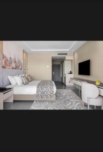 a bedroom with a bed and a flat screen tv at St Helens in Bolton