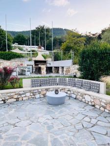 a stone patio with a fountain and a stone wall at green & blue villa in Glykadi +20 photos