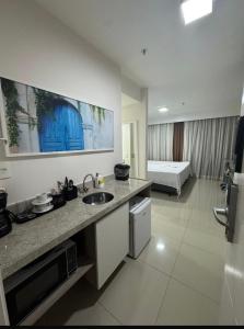 a kitchen with a sink and a couch in a room at True América apart-hotel in Campos dos Goytacazes