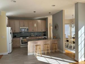 a kitchen with wooden cabinets and a white refrigerator at Bayside Gem in Beach Haven Crest