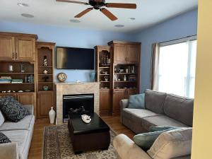 a living room with a couch and a ceiling fan at Bayside Gem in Beach Haven Crest