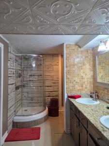 a bathroom with a shower and two sinks and a tub at Cozy Mobay in Hampton +48 photos