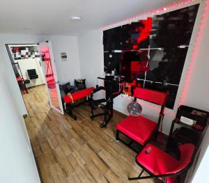 a living room with red chairs and a mirror at Escondite de Amor in La Vega