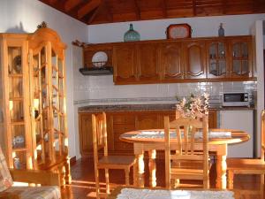 a kitchen with a table and some wooden cabinets at Casa Los Viñedos A in Fuencaliente de la Palma