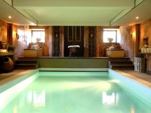 a swimming pool in the middle of a room at Alphen Retreat with Sauna in Alphen