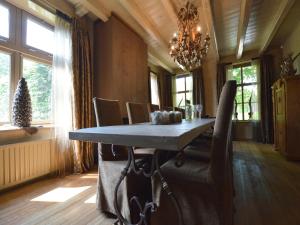a dining room with a table and chairs and a chandelier at Alphen Retreat with Sauna in Alphen