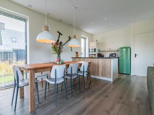 a kitchen and dining room with a wooden table and chairs at Fantastic villa located by a lake in Sint Nicolaasga +23 photos