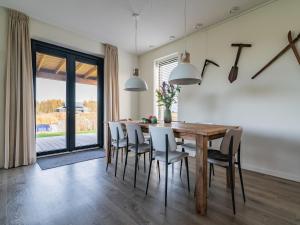 a dining room with a wooden table and chairs at Fantastic villa located by a lake in Sint Nicolaasga