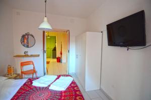 1 dormitorio con 1 cama y TV en la pared en Shine Apartment, en Nápoles