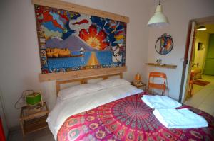 1 dormitorio con 1 cama con una pintura en la pared en Shine Apartment, en Nápoles