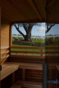 a window in a wooden cabin with a tree in the background at Miravino, winery stay with outdoor sauna and spa in McLaren Vale