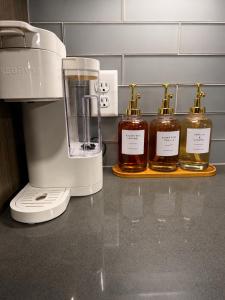 three bottles of honey on a counter next to a blender at Excel Grand Stays in Frisco