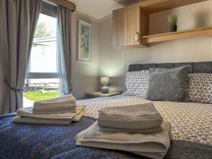 a bedroom with a bed with four pillows on it at Hamilton Unit 145 in Eyemouth