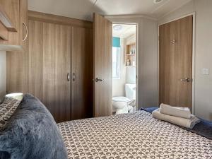 a bedroom with a bed and a bathroom with a toilet at Hamilton Unit 145 in Eyemouth