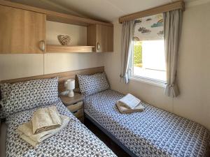 two twin beds in a small room with a window at Hamilton Unit 145 in Eyemouth