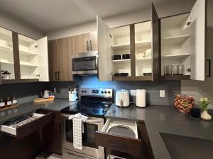a kitchen with stainless steel appliances and wooden cabinets at Excel Grand Stays in Frisco