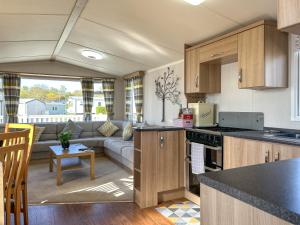 a kitchen and living room with a couch at Hamilton Unit 145 in Eyemouth +2 photos