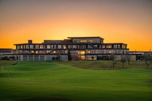 a building on a golf course at sunset at Excel Grand Stays in Frisco