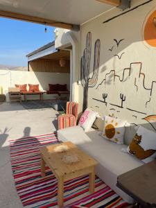 a couch on a patio with a wall with a cactus at Coastal Haven Surf Morocco in Aourir
