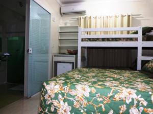 a bedroom with a bed with a green and white bedspread at Pousada Ares do Sul in Penha