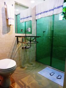 a bathroom with a toilet and a glass shower at Pousada Ares do Sul in Penha