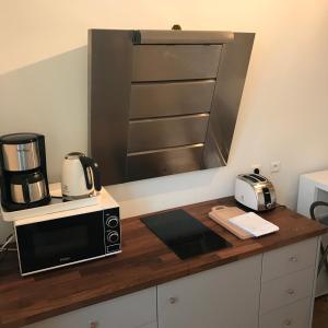 a kitchen with a microwave and a coffee maker on a counter at Appartement, Lyon, Villeurbanne in Villeurbanne