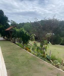 a garden with a gazebo and a green field at Casa das Bananeiras - 1 Quarto * Rota do Vinho in Bento Gonçalves
