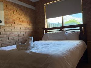 a bedroom with a white bed with a window at Entire 2 bedrooms unit in Geraldton