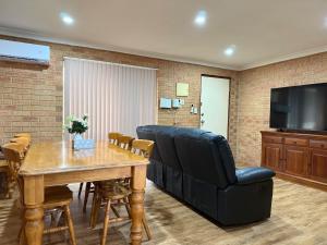 a living room with a couch and a table and a television at Entire 2 bedrooms unit in Geraldton