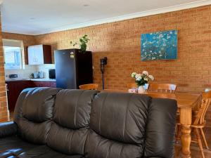 a living room with a leather couch and a table at Entire 2 bedrooms unit in Geraldton