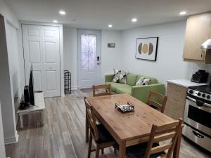 a living room with a table and a green couch at Private Entry-Modern & Bright Longueuil Suite in Longueuil