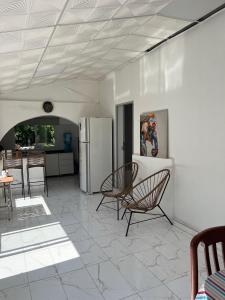 a living room with two chairs and a refrigerator at Casa Quinta La Jaula in Isla Paracao