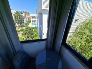 a room with two windows with a table and a toilet at Apartamente VILLA 7 On The Beach in Eforie Nord