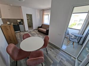 a living room with a white table and chairs at Apartamente VILLA 7 On The Beach in Eforie Nord