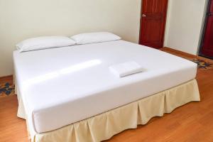 ein weißes Bett mit zwei Kissen darauf in der Unterkunft Cozy Corner in San Fernando